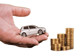 Hand holding car next to stack of coins